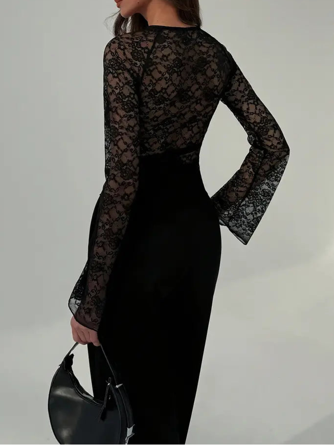 Woman wearing a black sheer lace dress against a plain background